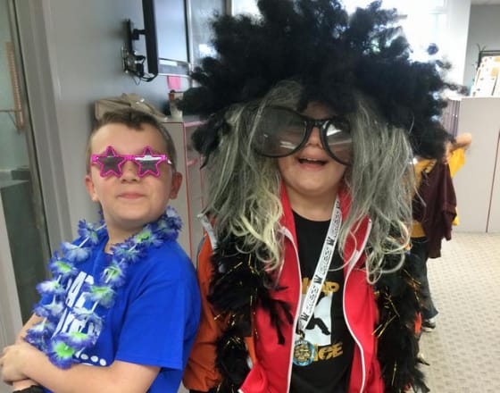 Two boys dressed up with silly glasses and wigs at Bauer Fine Arts Academy