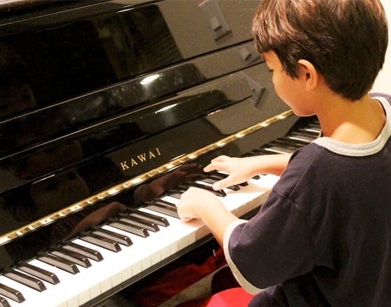 Boy playing a piano at Bauer Fine Arts Academy
