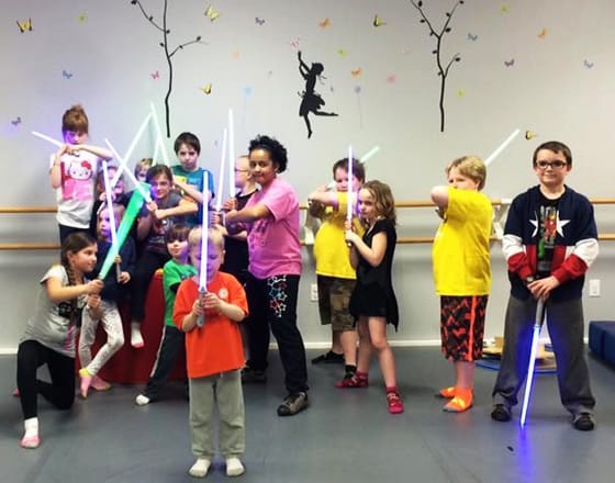 Young kids holding light sticks at Bauer Fine Arts Academy